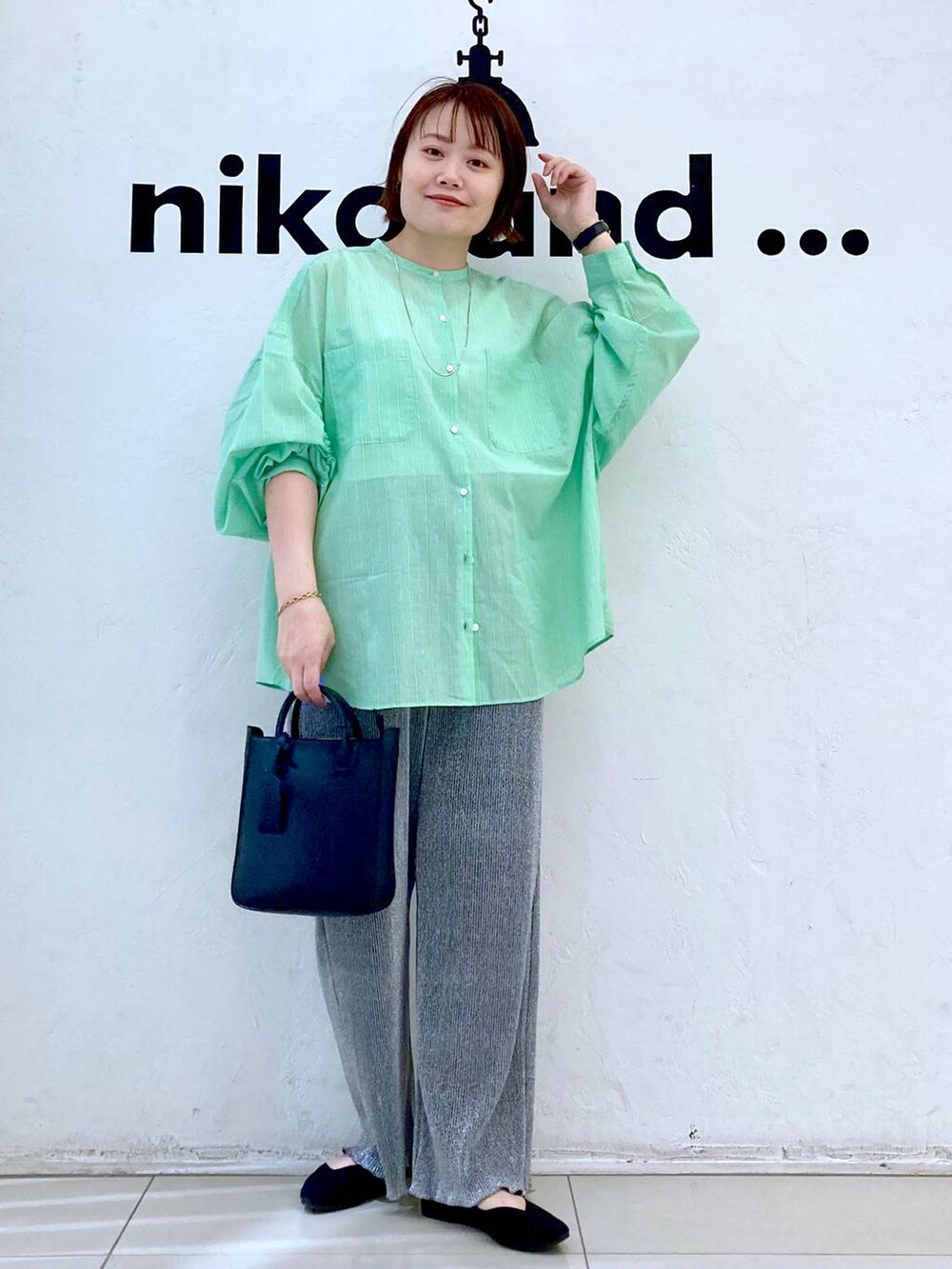 ブラック系のトートバッグ、グレー系のその他パンツ、ベージュ系のタンクトップを着用したレディースの春コーディネートの2枚目の写真
