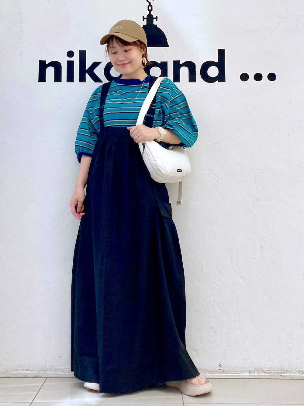 ベージュ系のサンダル、ホワイト系のショルダーバッグ、グリーン系のTシャツ/カットソーを着用したレディースの春コーディネートの2枚目の写真