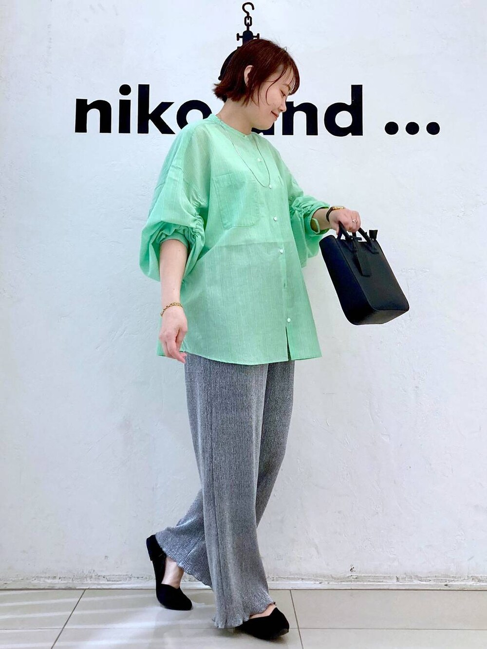 ブラック系のトートバッグ、グレー系のその他パンツ、ベージュ系のタンクトップを着用したレディースの春コーディネートの3枚目の写真
