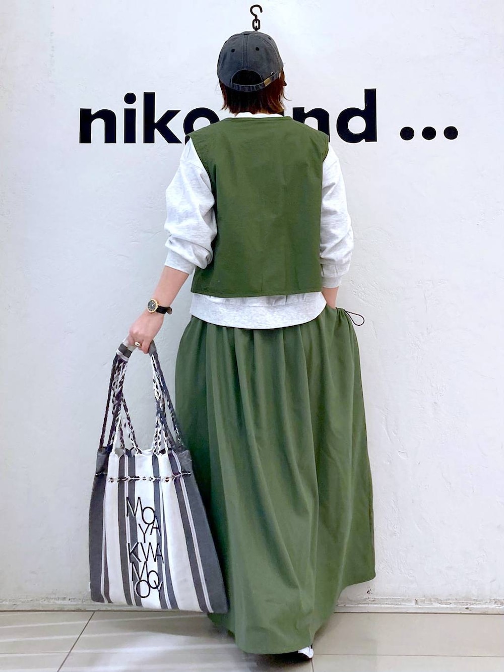 グリーン系のスカート、ベージュ系のTシャツ/カットソー、グリーン系のベストを着用したレディースの春コーディネートの4枚目の写真