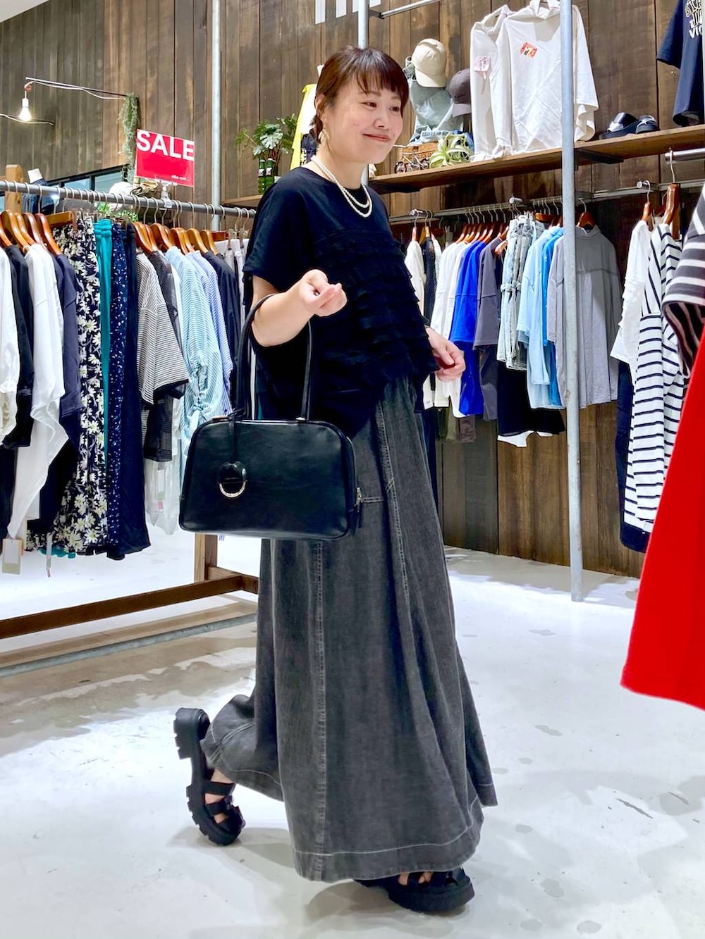 グレー系のスカート、ブラック系のボストンバッグ、ブラック系のTシャツ/カットソーを着用したレディースの夏コーディネートの5枚目の写真