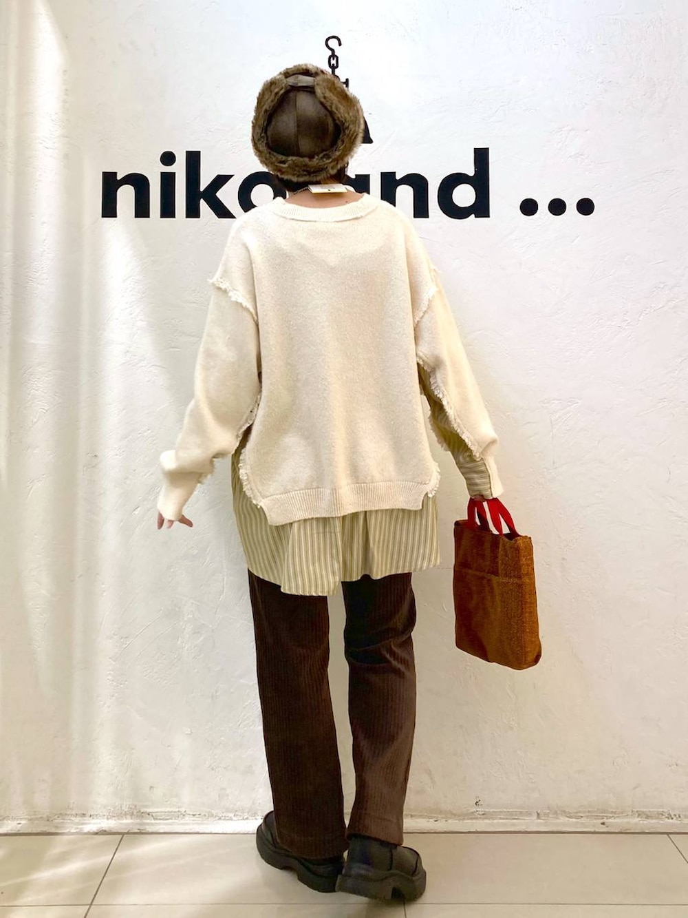 ブラウン系のその他パンツ、ブラック系のブーツ、レッド系のトートバッグを着用したレディースの冬コーディネートの5枚目の写真