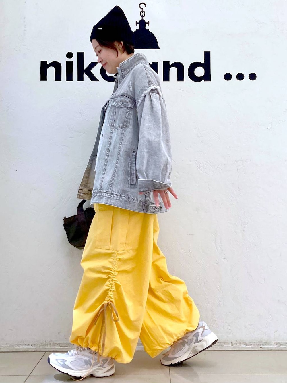 ベージュ系のスウェット、グレー系のデニムジャケット、ホワイト系のスニーカーを着用したレディースの冬コーディネートの5枚目の写真