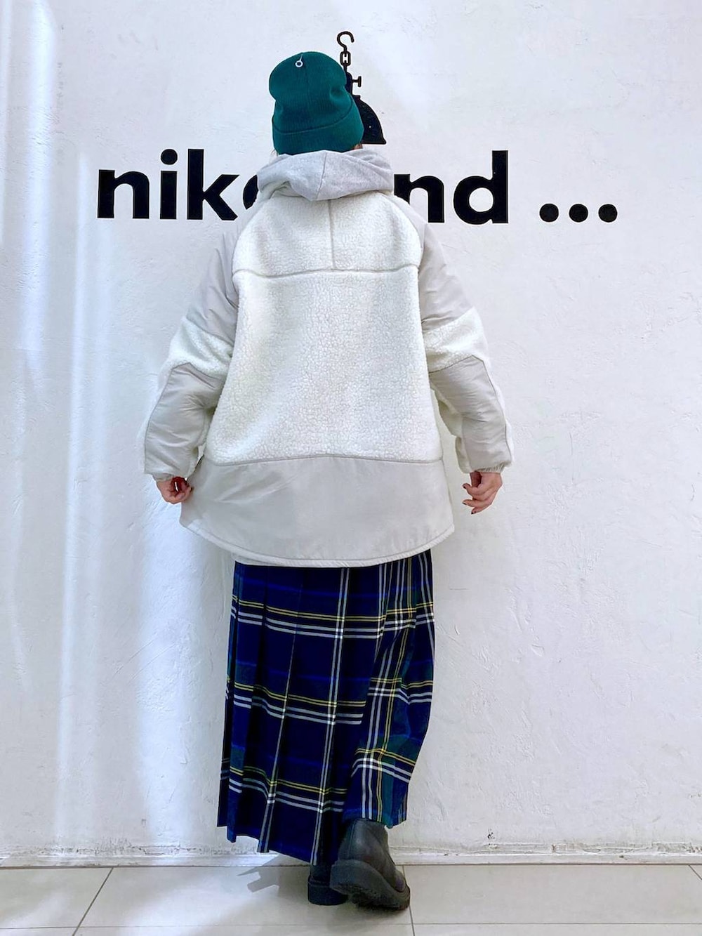 グレー系のパーカー、ベージュ系のブルゾン、ブラウン系のスカートを着用したレディースの秋コーディネートの4枚目の写真