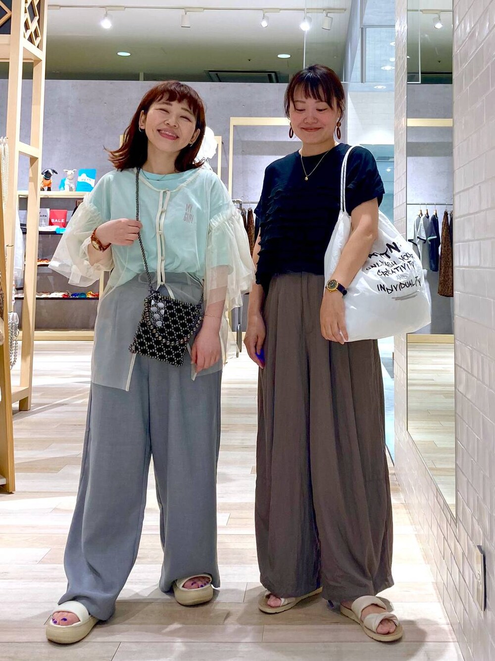 ブラック系のショルダーバッグ、ホワイト系のTシャツ/カットソー、ブラック系のTシャツ/カットソーを着用したレディースの夏コーディネートの2枚目の写真