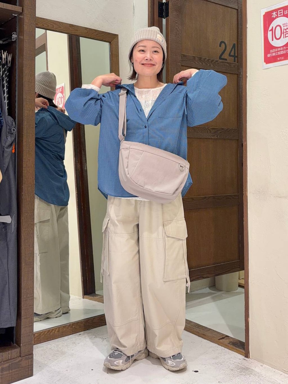 ベージュ系のカーゴパンツ、ブルー系のシャツ/ブラウス、グレー系のショルダーバッグを着用したレディースの春コーディネートの5枚目の写真