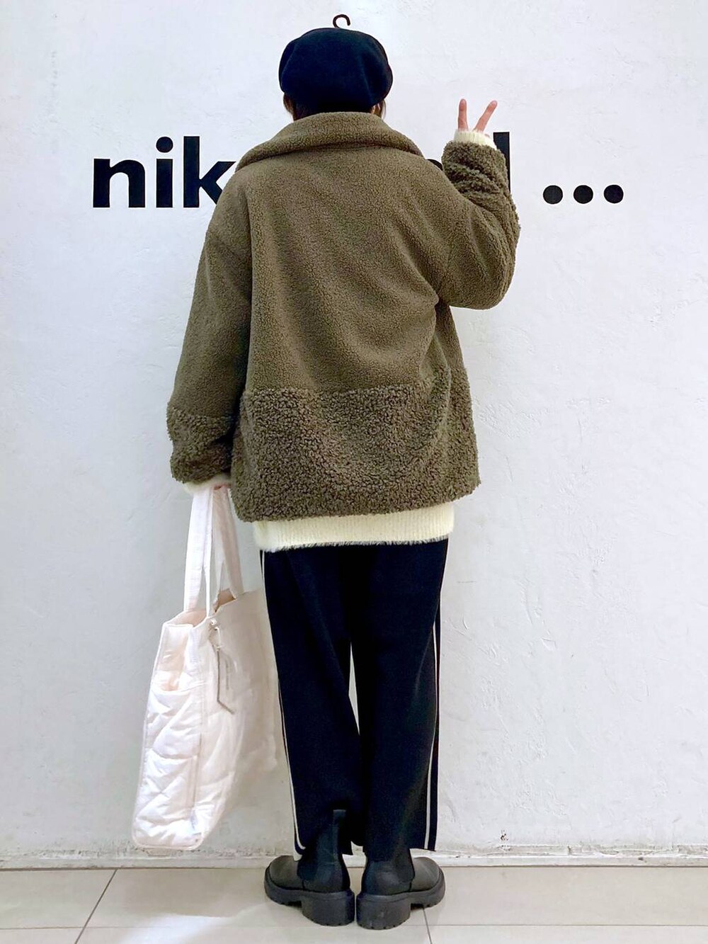 グリーン系のその他アウター、ホワイト系のその他パンツ、ブラック系のブーツを着用したレディースの冬コーディネートの5枚目の写真