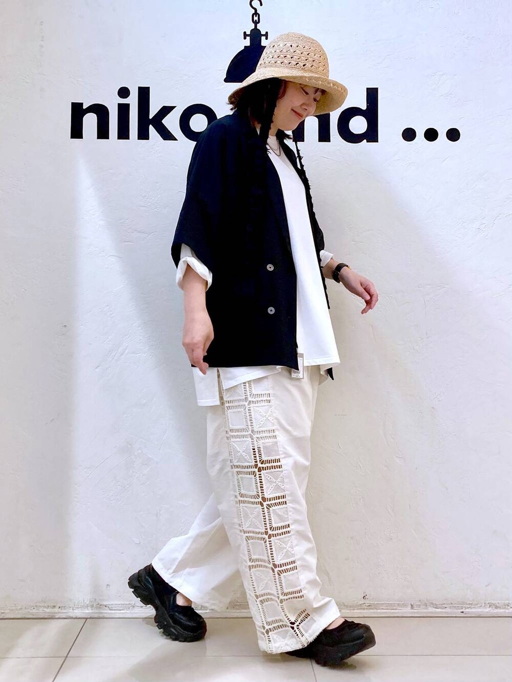 ホワイト系のTシャツ/カットソー、ブラック系のスニーカー、ベージュ系のその他パンツを着用したレディースの春コーディネートの5枚目の写真