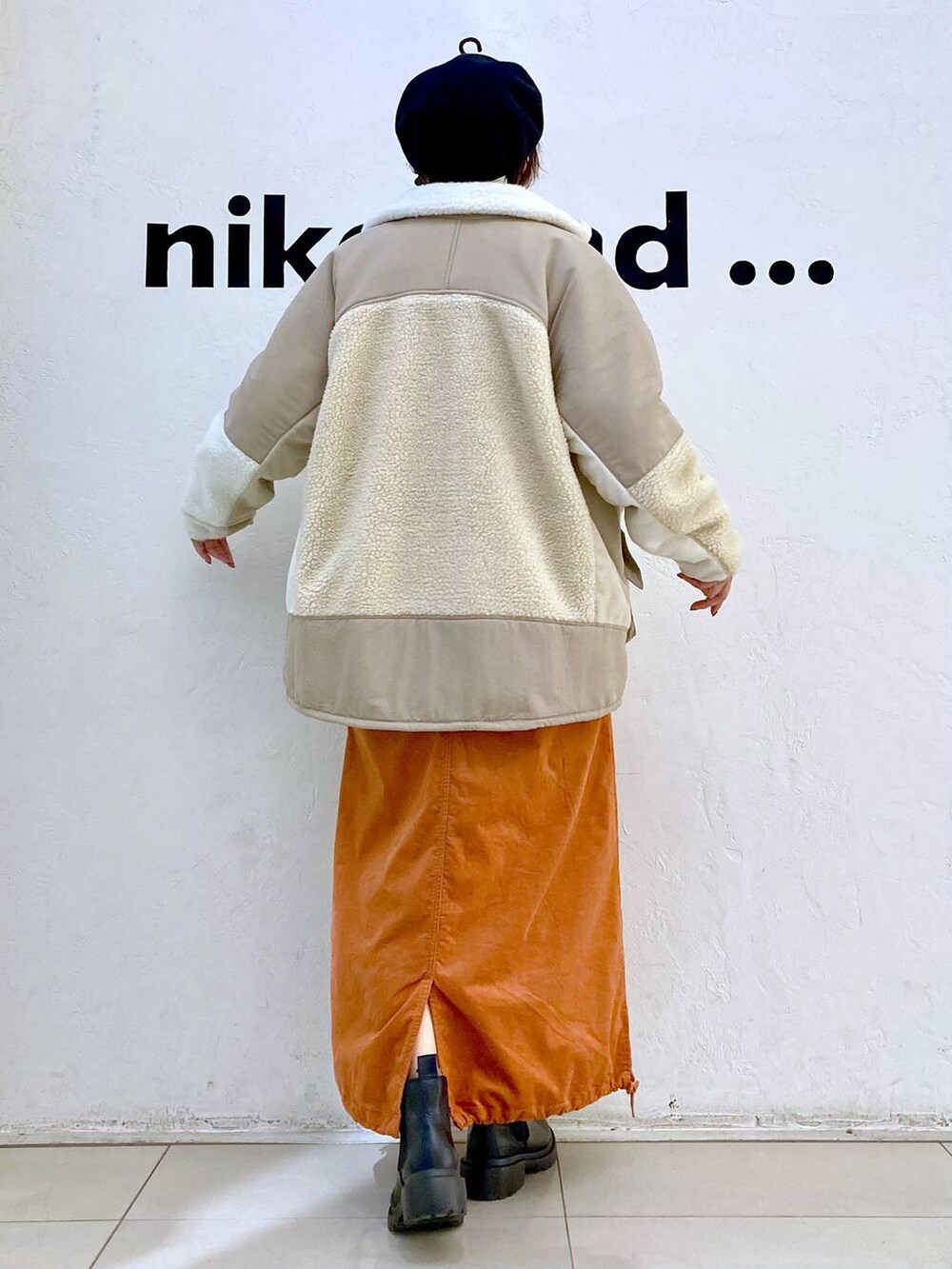 ベージュ系のその他アウター、ホワイト系のニット/セーター、ブラック系のブーツを着用したレディースの冬コーディネートの3枚目の写真