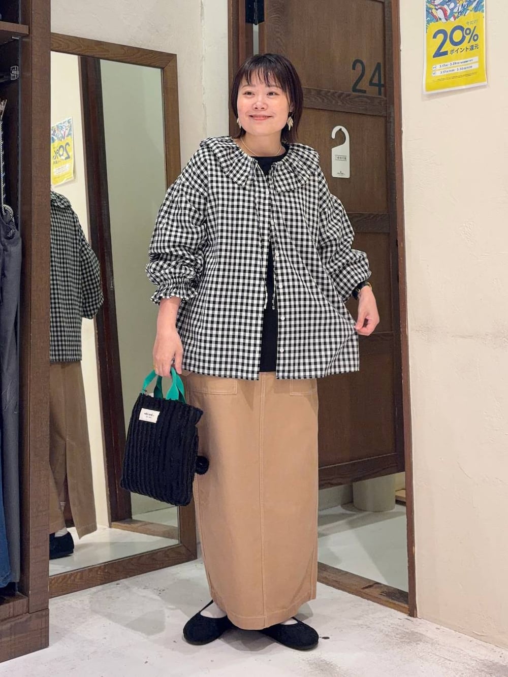 イエロー系のスカート、ブラック系のパンプス、ブラック系のトートバッグを着用したレディースの春コーディネートの5枚目の写真