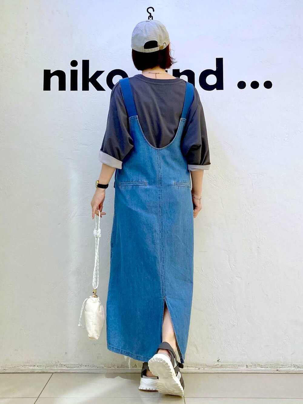 ホワイト系のショルダーバッグ、グレー系のTシャツ/カットソー、ブルー系のジャンパースカートを着用したレディースの夏コーディネートの4枚目の写真