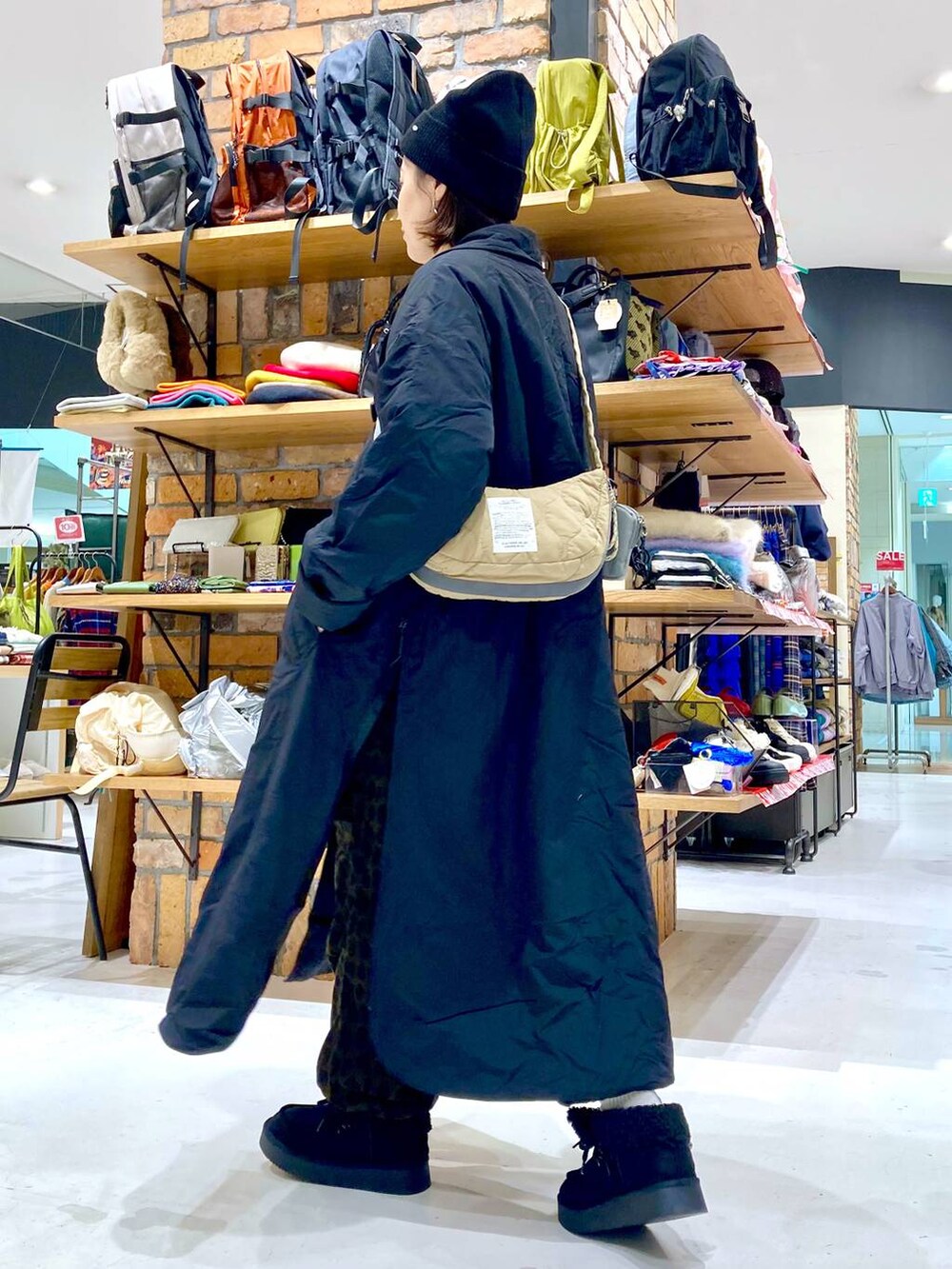 ベージュ系のショルダーバッグ、ホワイト系のTシャツ/カットソー、ブラック系のモカシン/デッキシューズを着用したレディースの冬コーディネートの3枚目の写真