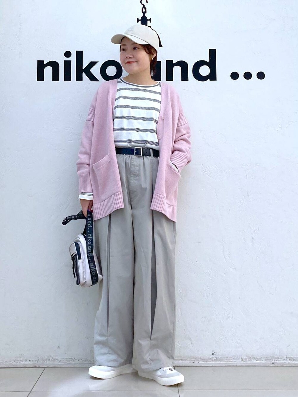 ホワイト系のスニーカー、イエロー系のショルダーバッグ、グレー系のチノパンツを着用したレディースの冬コーディネートの2枚目の写真