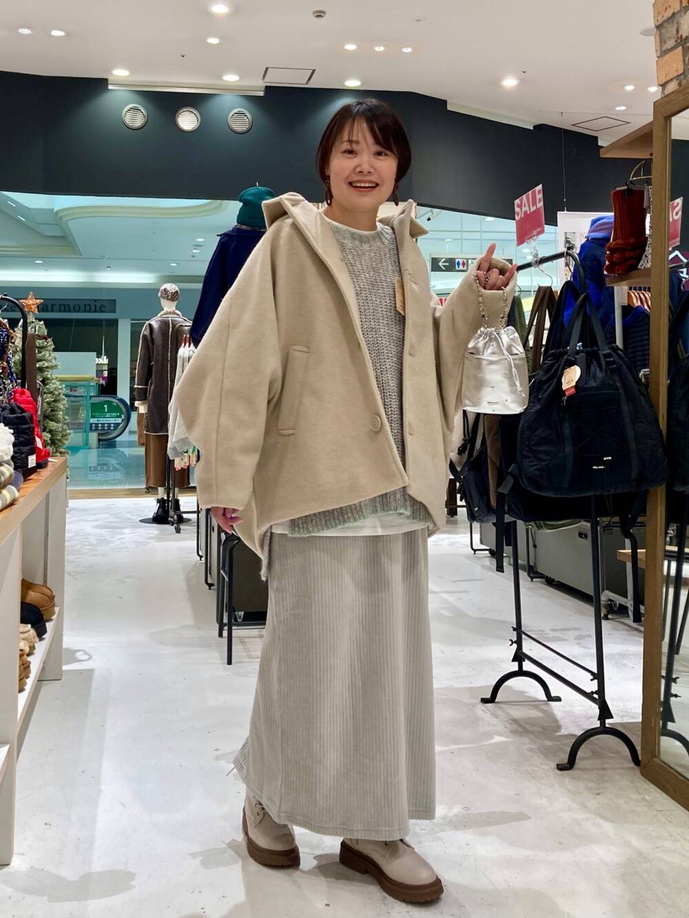 シルバー系のショルダーバッグ、ベージュ系のブーツ、ベージュ系のブルゾンを着用したレディースの冬コーディネートの5枚目の写真