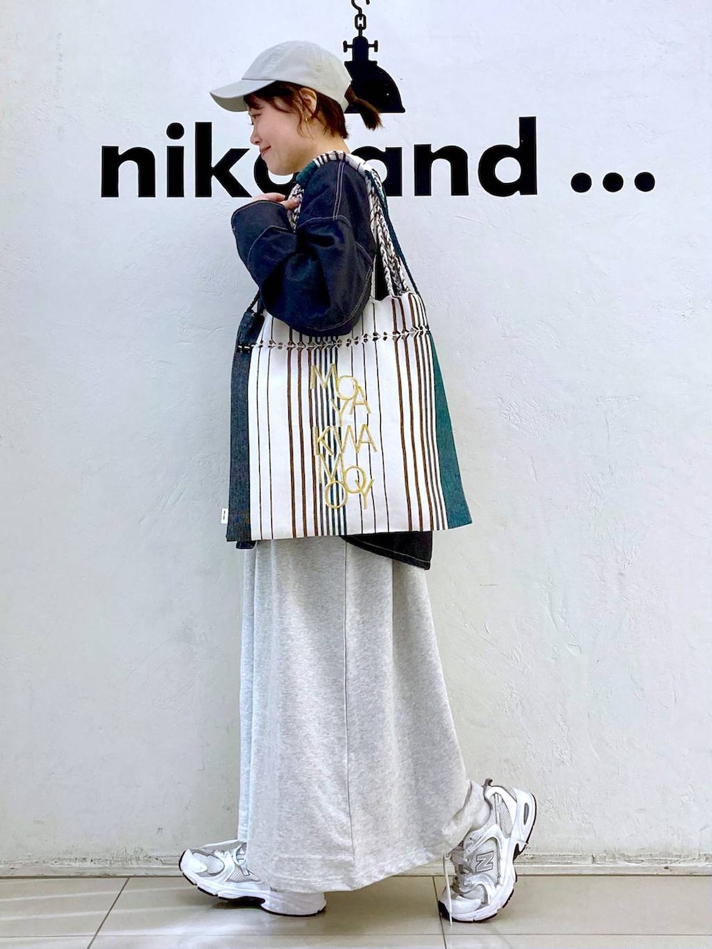 ベージュ系のワンピース、ブラック系のトートバッグ、その他のブルゾンを着用したレディースの春コーディネートの3枚目の写真