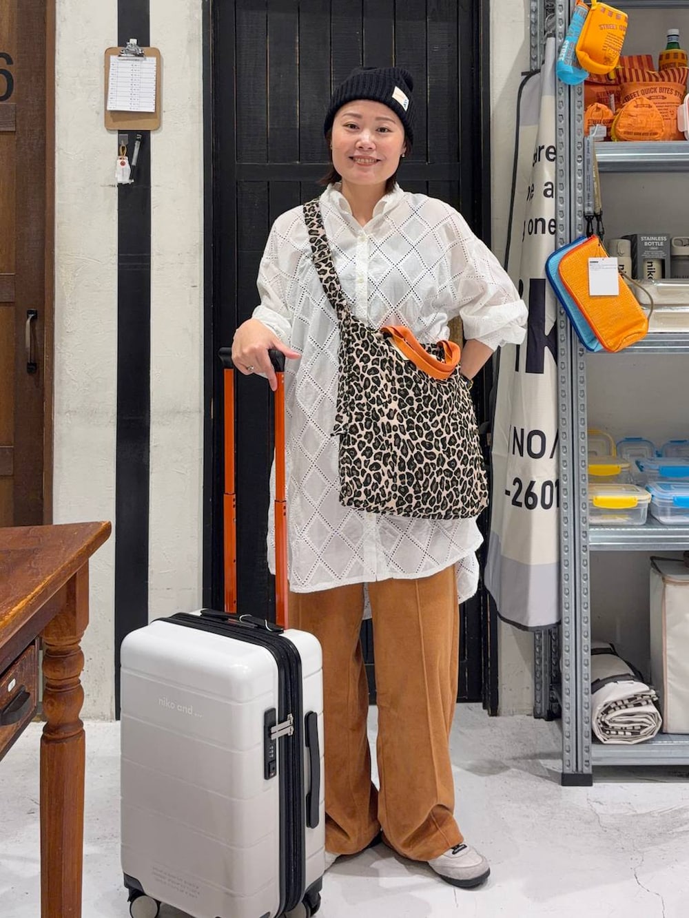 その他のトートバッグ、オレンジ系のその他パンツ、ホワイト系のチュニックを着用したレディースの春コーディネートの3枚目の写真