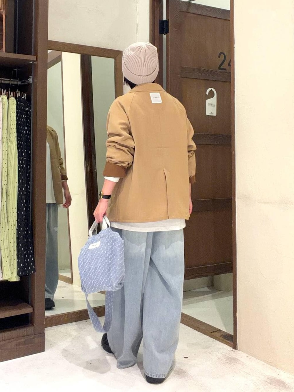 ブルー系のトートバッグ、ブルー系のデニムパンツ、その他のネックレスを着用したレディースの冬コーディネートの4枚目の写真