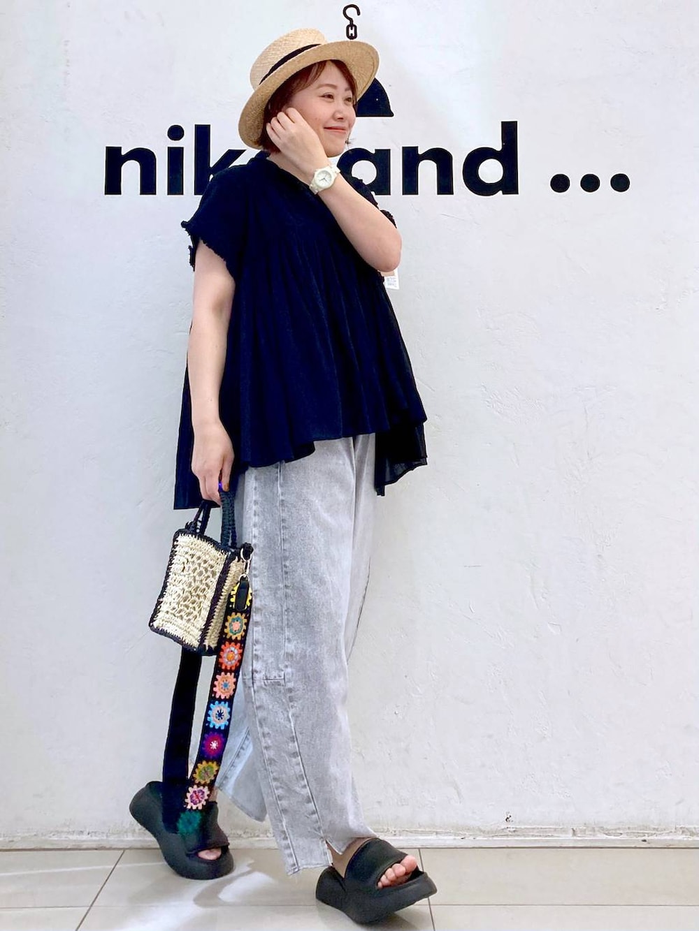 ブラック系のショルダーバッグ、ブラック系のサンダル、グレー系のデニムパンツを着用したレディースの春コーディネートの3枚目の写真