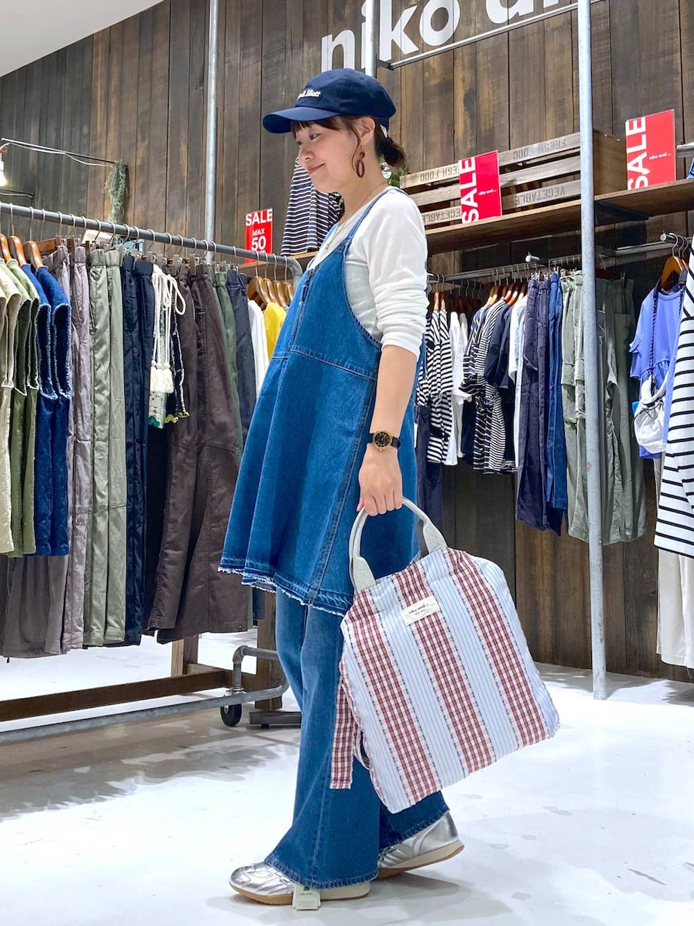 シルバー系のスニーカー、ブルー系のデニムパンツ、ブルー系のキャミソールを着用したレディースの夏コーディネートの2枚目の写真