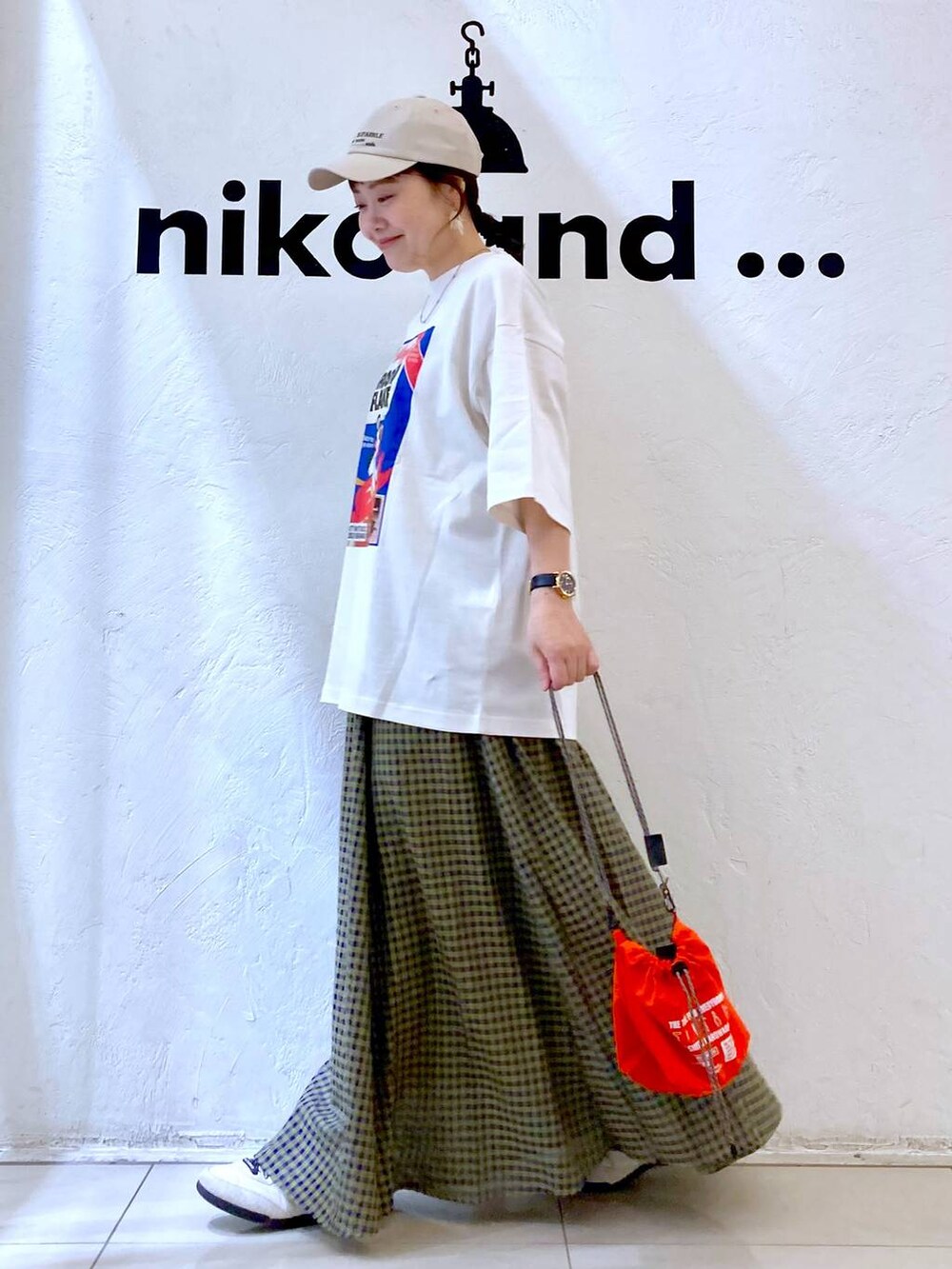 ホワイト系のスニーカー、オレンジ系のショルダーバッグ、ホワイト系のTシャツ/カットソーを着用したレディースの春コーディネートの3枚目の写真