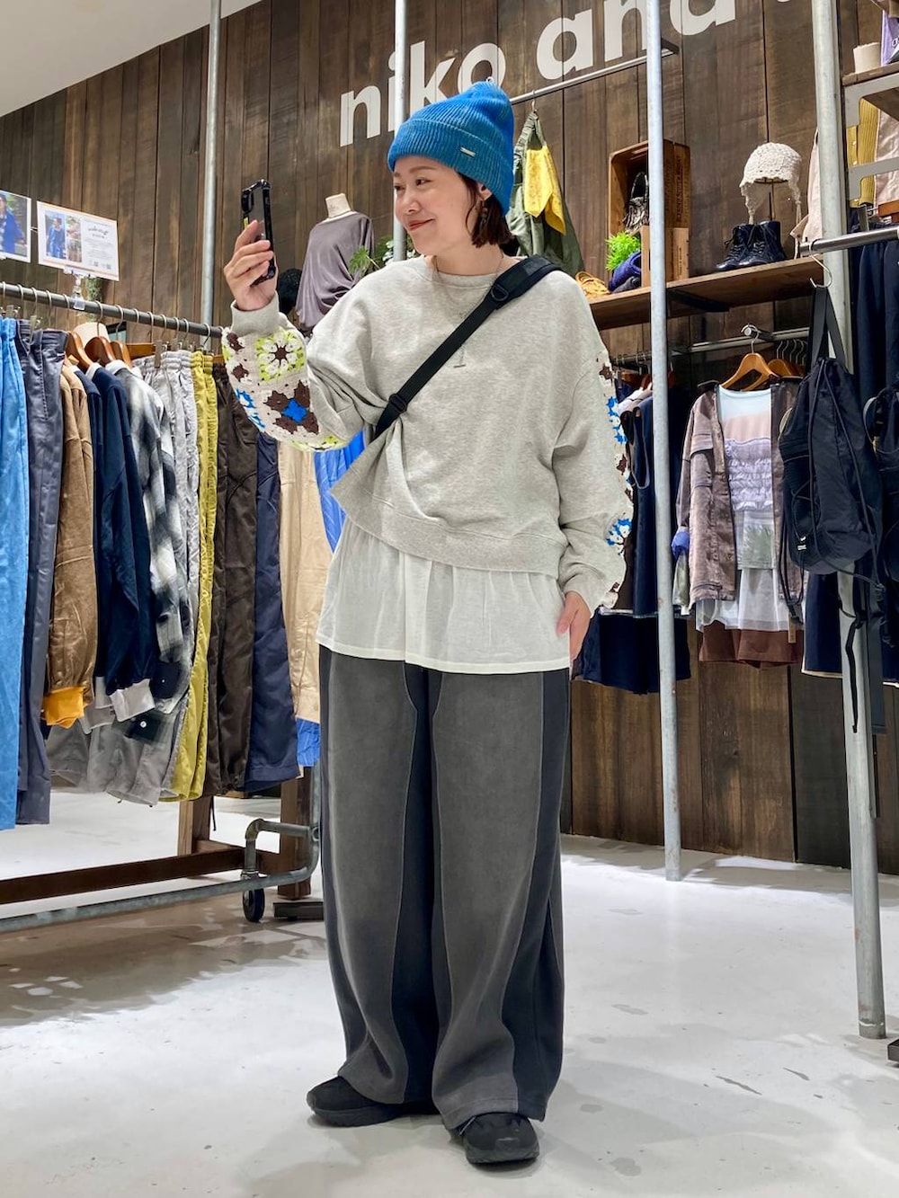 グレー系のスウェット、ブラック系のデニムパンツ、ホワイト系のTシャツ/カットソーを着用したレディースの秋コーディネートの2枚目の写真