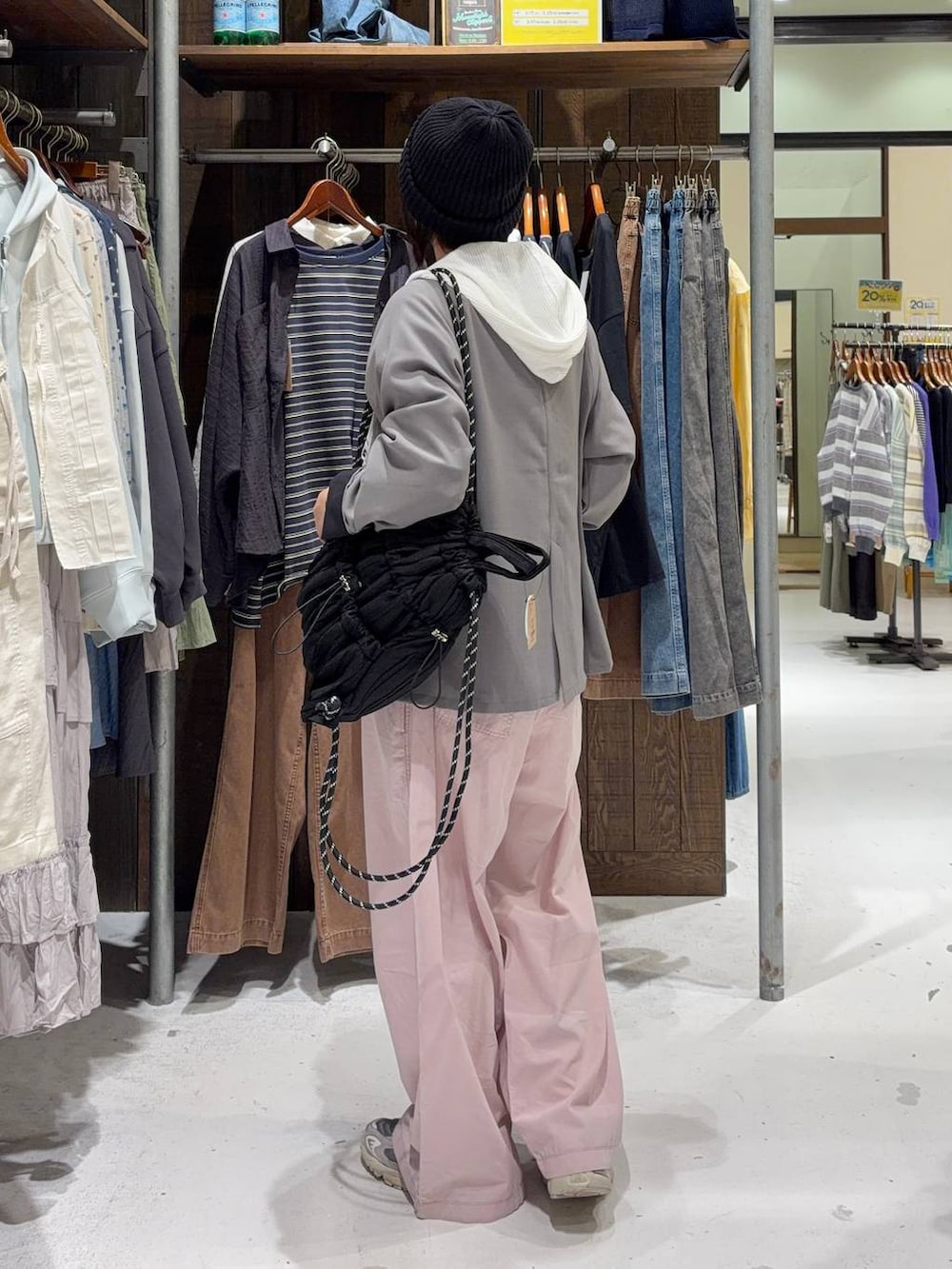 ピンク系のサロペット/オーバーオール、ホワイト系のパーカー、ブラック系のバックパック/リュックを着用したレディースの春コーディネートの4枚目の写真