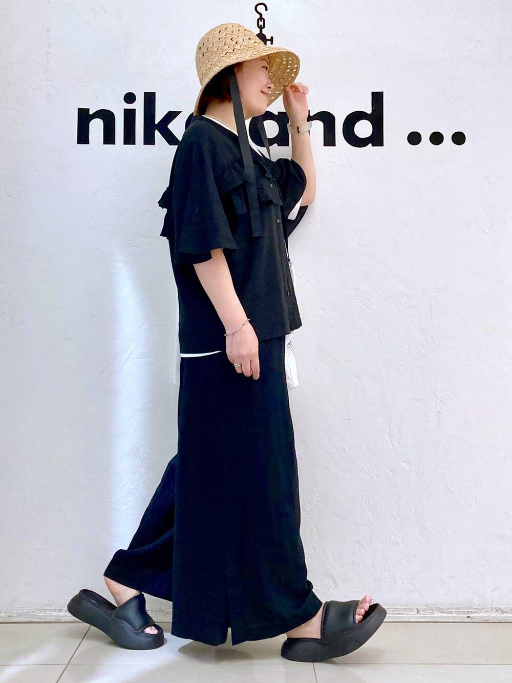 ブラック系のサンダル、ブラック系のその他パンツ、ホワイト系のTシャツ/カットソーを着用したレディースの夏コーディネートの5枚目の写真