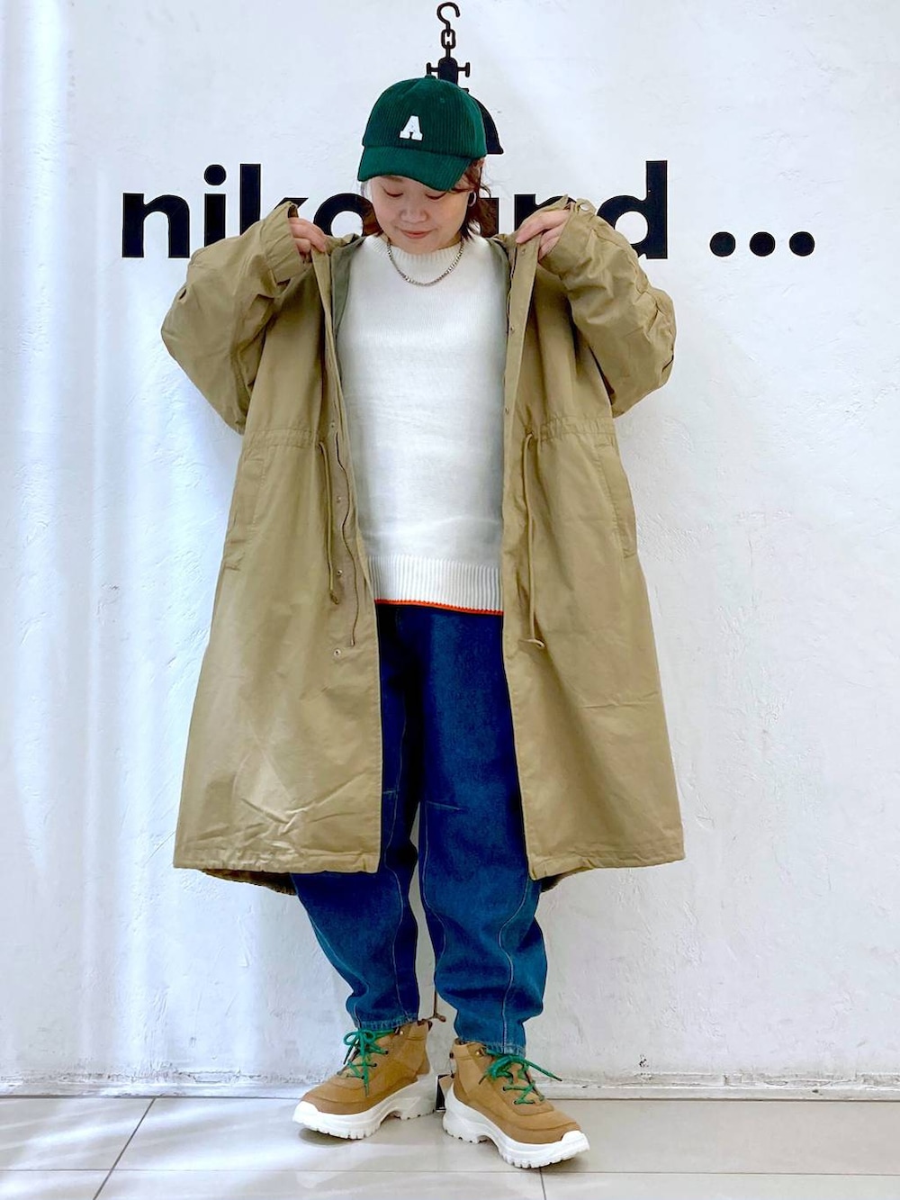 ベージュ系のニット/セーター、ブルー系のその他パンツ、イエロー系のモッズコートを着用したレディースの秋コーディネートの2枚目の写真