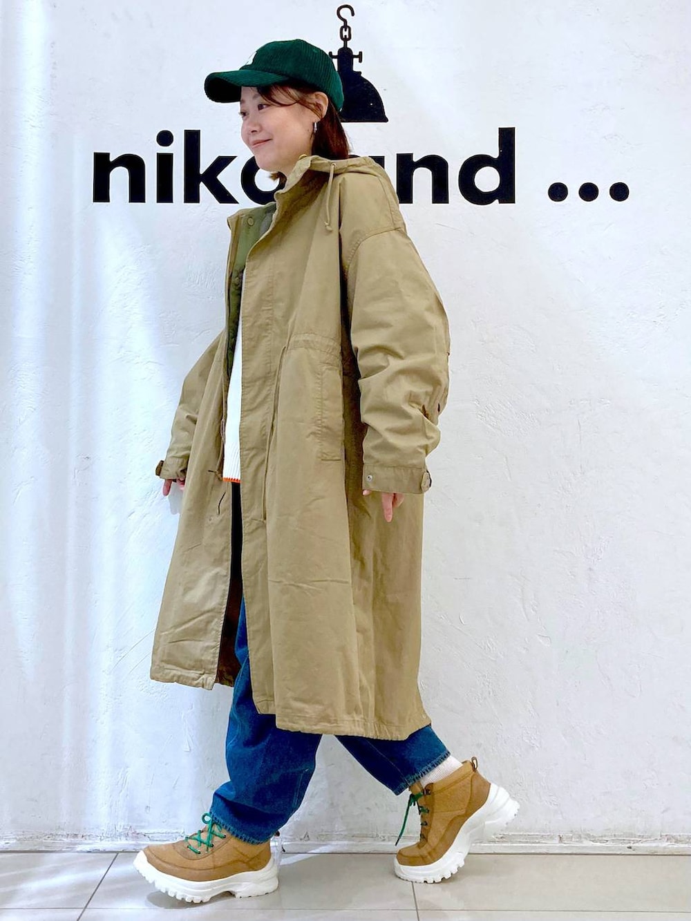 ベージュ系のニット/セーター、ブルー系のその他パンツ、イエロー系のモッズコートを着用したレディースの秋コーディネートの3枚目の写真