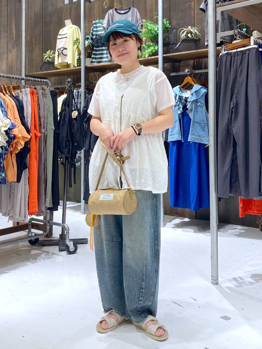 ブルー系のその他パンツ、ホワイト系のベスト、ベージュ系のショルダーバッグを着用したレディースの夏コーディネートの2枚目の写真