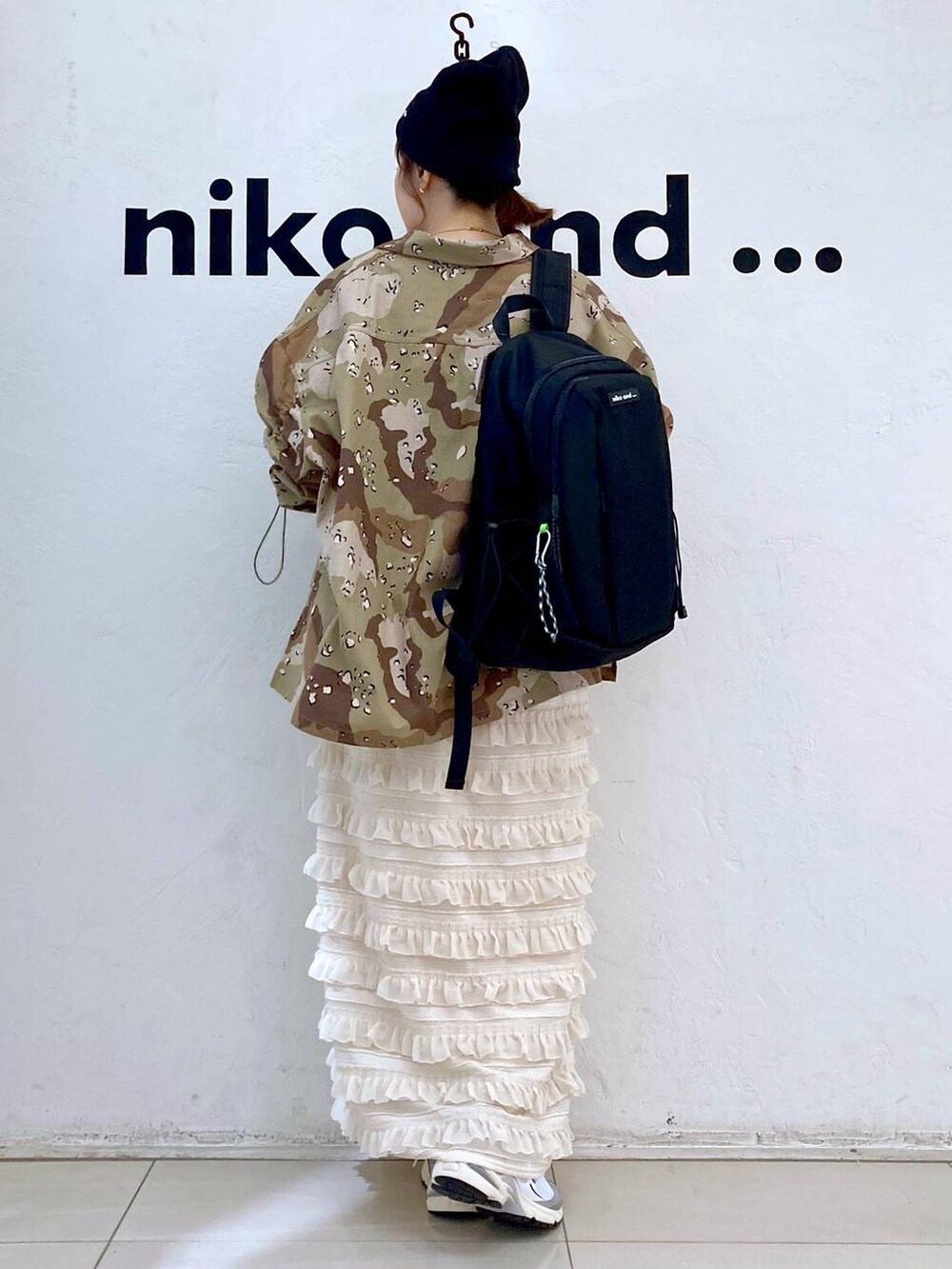 グレー系のスニーカー、ベージュ系のスカート、グレー系のバックパック/リュックを着用したレディースの秋コーディネートの4枚目の写真