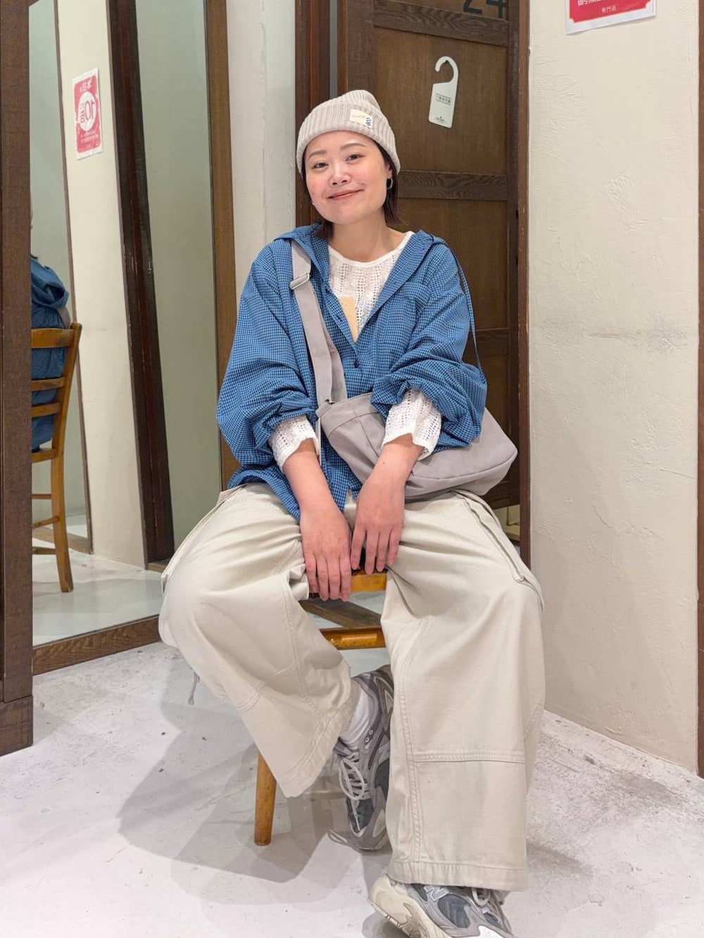 ベージュ系のカーゴパンツ、ブルー系のシャツ/ブラウス、グレー系のショルダーバッグを着用したレディースの春コーディネートの3枚目の写真