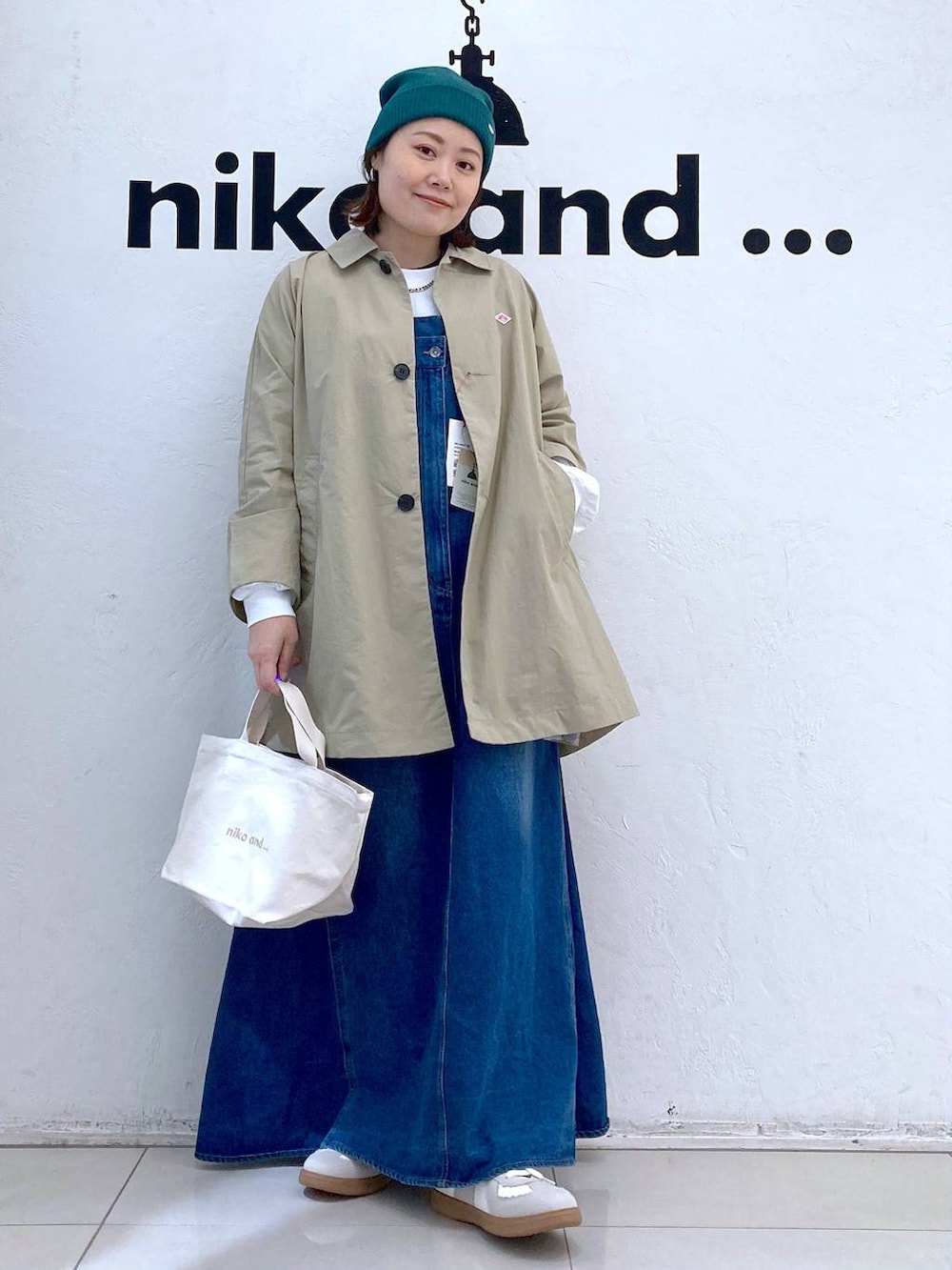 ホワイト系のスニーカー、ホワイト系のトートバッグ、シルバー系のピアス（両耳用）を着用したレディースの春コーディネートの2枚目の写真