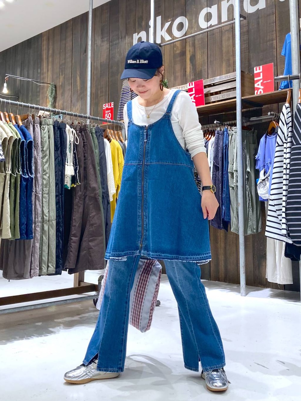 シルバー系のスニーカー、ブルー系のデニムパンツ、ブルー系のキャミソールを着用したレディースの夏コーディネートの5枚目の写真