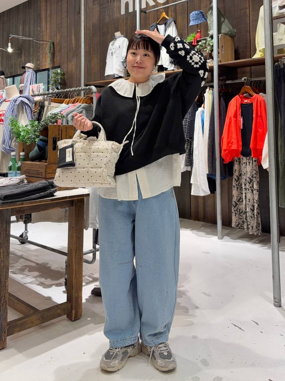 ブラック系のスウェット、ホワイト系のトートバッグ、ブルー系のその他パンツを着用したレディースの春コーディネートの5枚目の写真