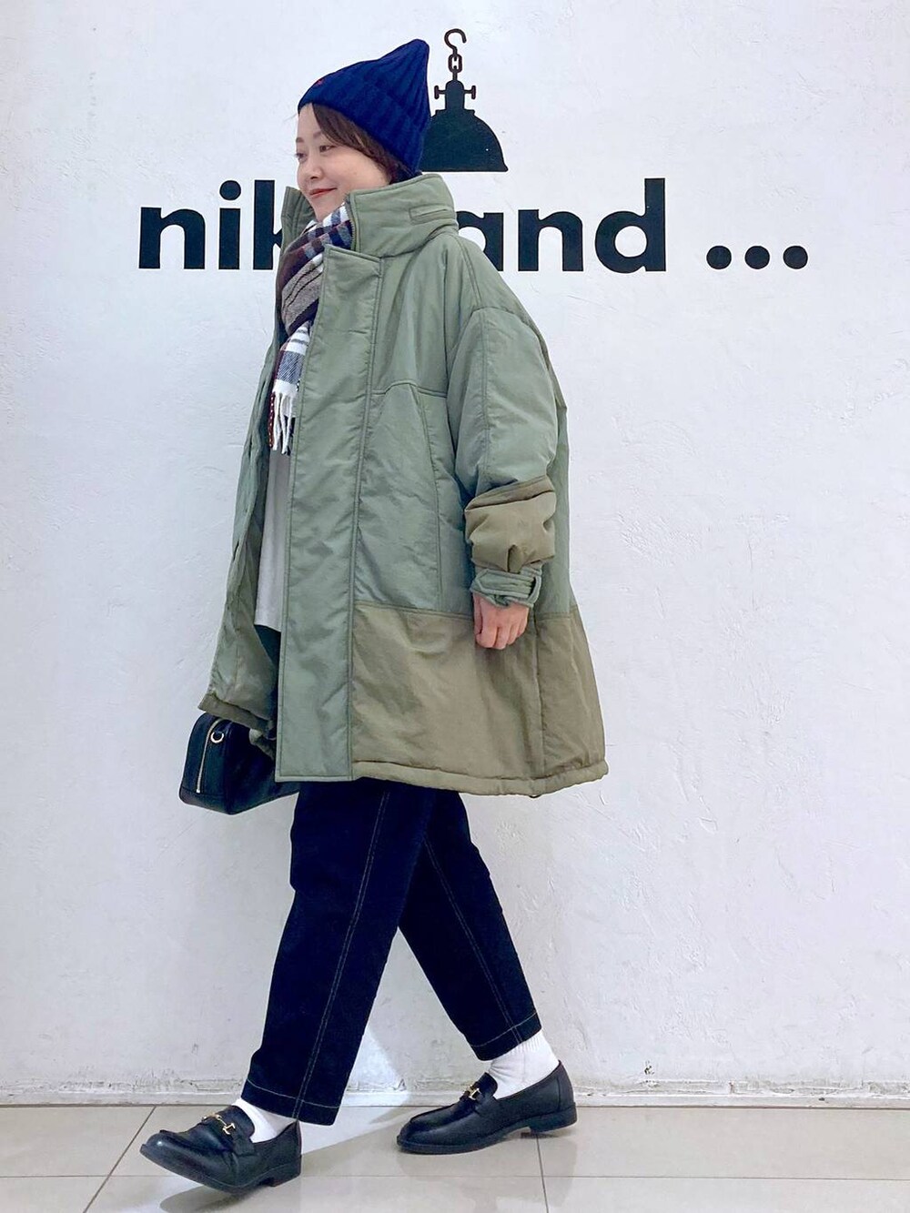 ブラック系のその他パンツ、グリーン系のブルゾン、ホワイト系のTシャツ/カットソーを着用したレディースの冬コーディネートの2枚目の写真