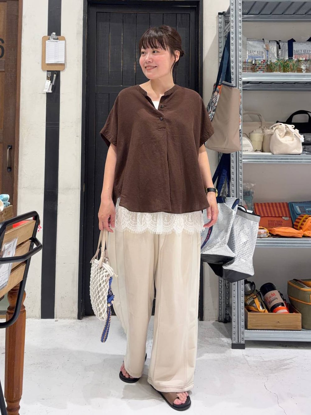 ベージュ系のデニムパンツ、ベージュ系のトートバッグ、ブラウン系のシャツ/ブラウスを着用したレディースの夏コーディネートの2枚目の写真