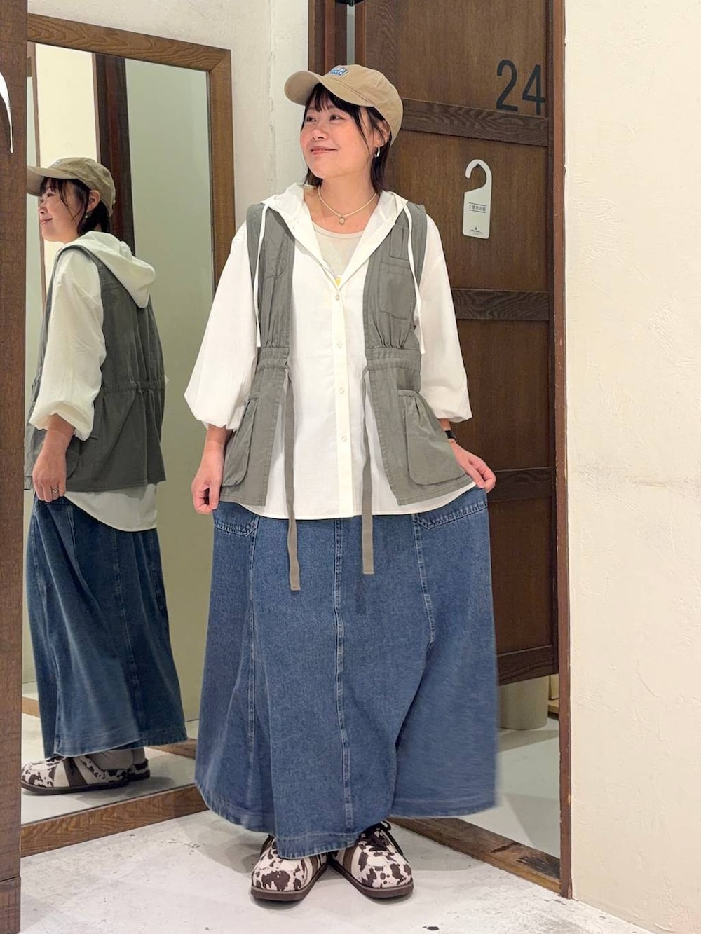 ブルー系のスカート、グリーン系のベスト、ホワイト系のシャツ/ブラウスを着用したレディースの春コーディネートの5枚目の写真