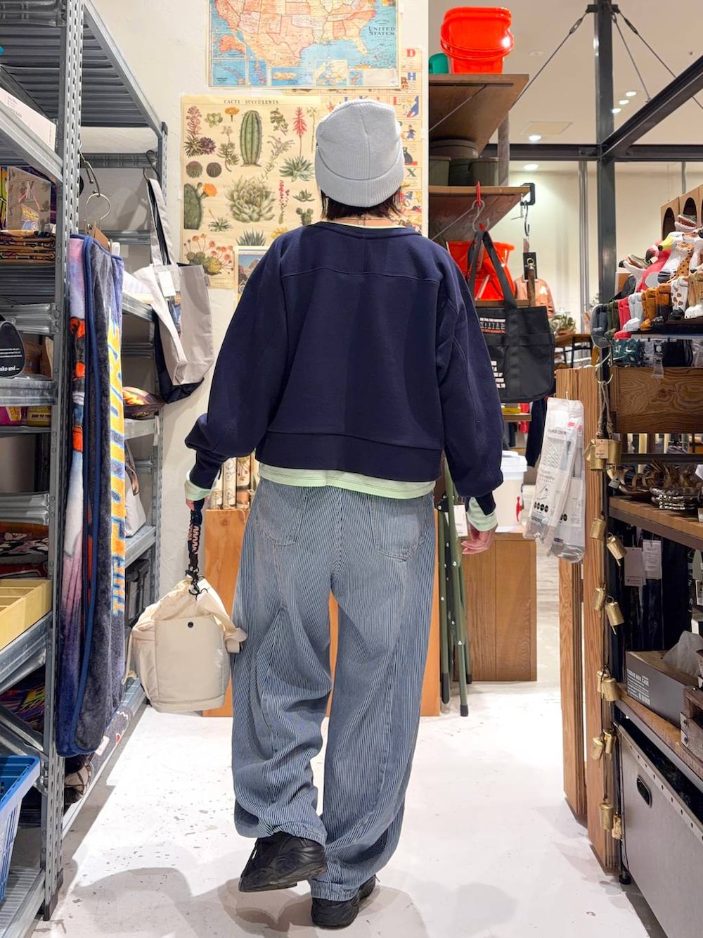 ブルー系のデニムパンツ、ブルー系のスウェット、ベージュ系のショルダーバッグを着用したレディースの冬コーディネートの5枚目の写真