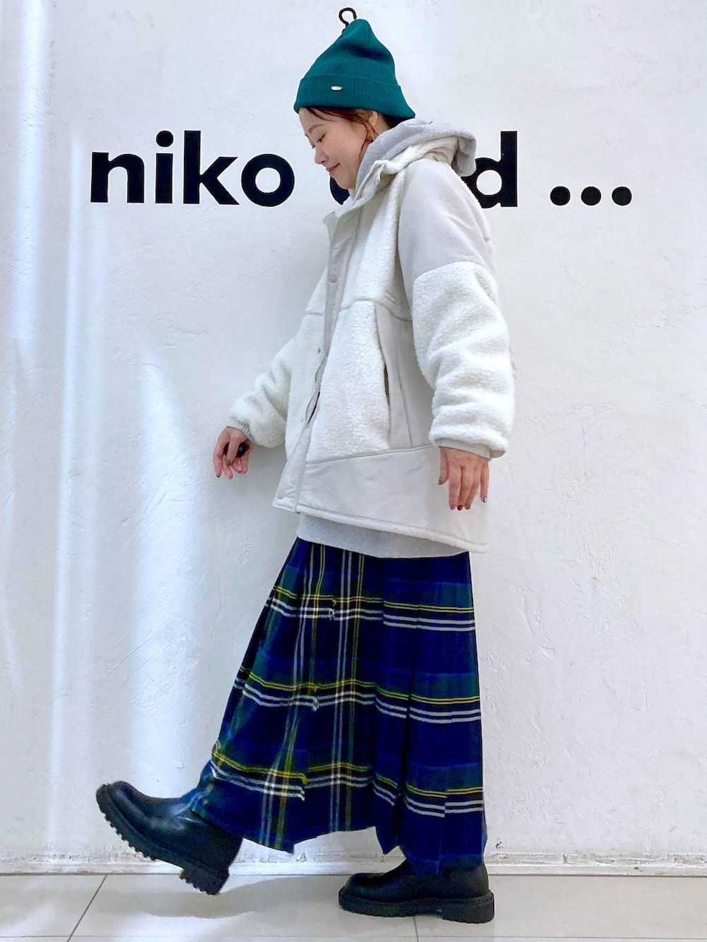 グレー系のパーカー、ベージュ系のブルゾン、ブラウン系のスカートを着用したレディースの秋コーディネートの3枚目の写真