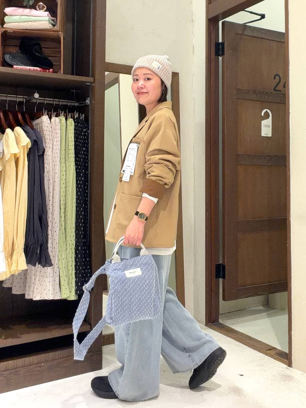 ブルー系のトートバッグ、ブルー系のデニムパンツ、その他のネックレスを着用したレディースの冬コーディネートの3枚目の写真