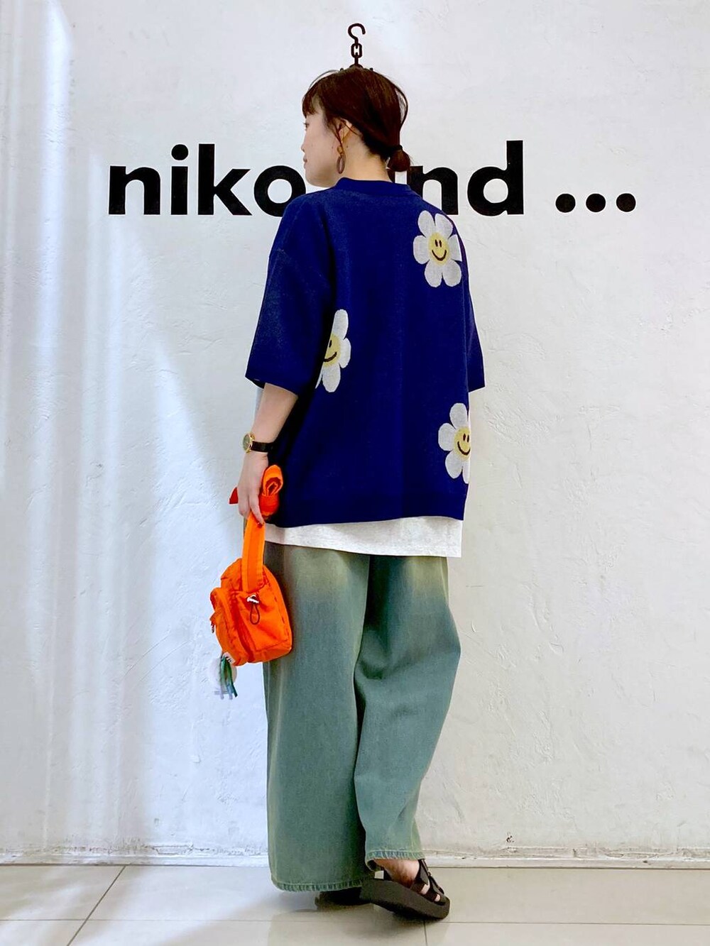 オレンジ系のショルダーバッグ、ベージュ系のTシャツ/カットソー、ブルー系のデニムパンツを着用したレディースの夏コーディネートの5枚目の写真