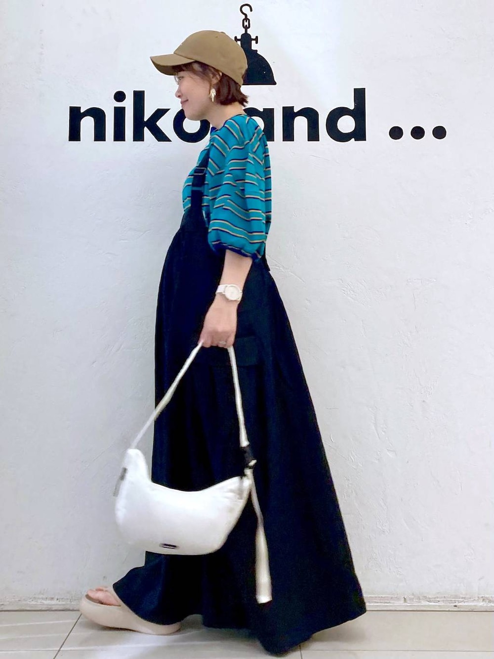 ベージュ系のサンダル、ホワイト系のショルダーバッグ、グリーン系のTシャツ/カットソーを着用したレディースの春コーディネートの3枚目の写真
