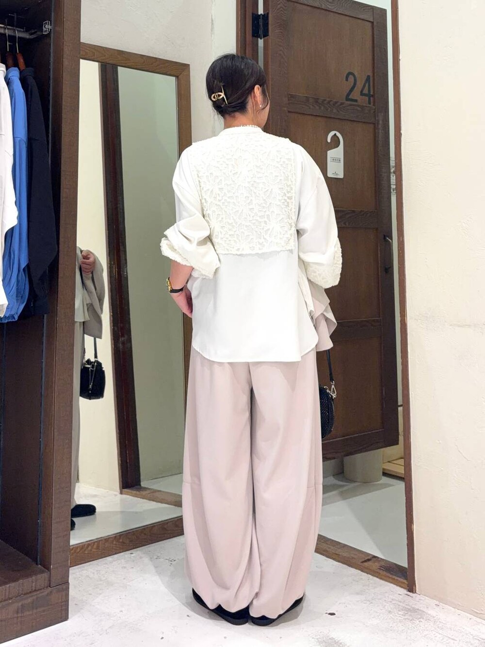 ブラック系のパンプス、ホワイト系のシャツ/ブラウス、その他のショルダーバッグを着用したレディースの冬コーディネートの3枚目の写真