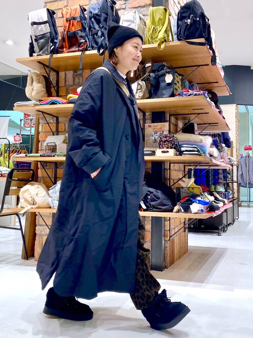 ベージュ系のショルダーバッグ、ホワイト系のTシャツ/カットソー、ブラック系のモカシン/デッキシューズを着用したレディースの冬コーディネートの4枚目の写真