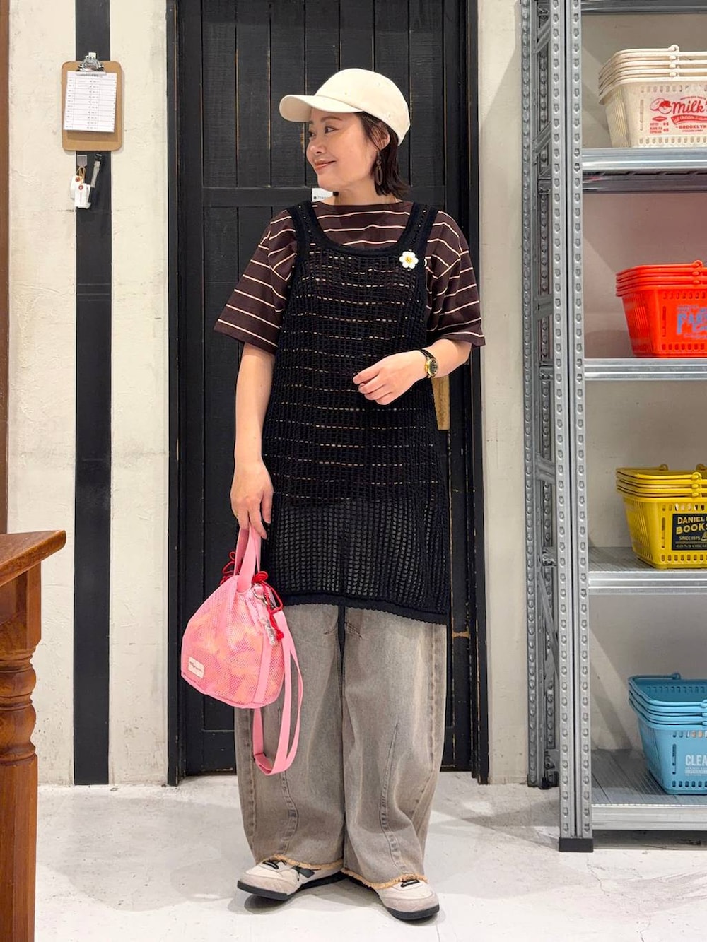 ピンク系のデニムパンツ、ブラウン系のTシャツ/カットソー、ブラック系のワンピースを着用したレディースの春コーディネートの4枚目の写真