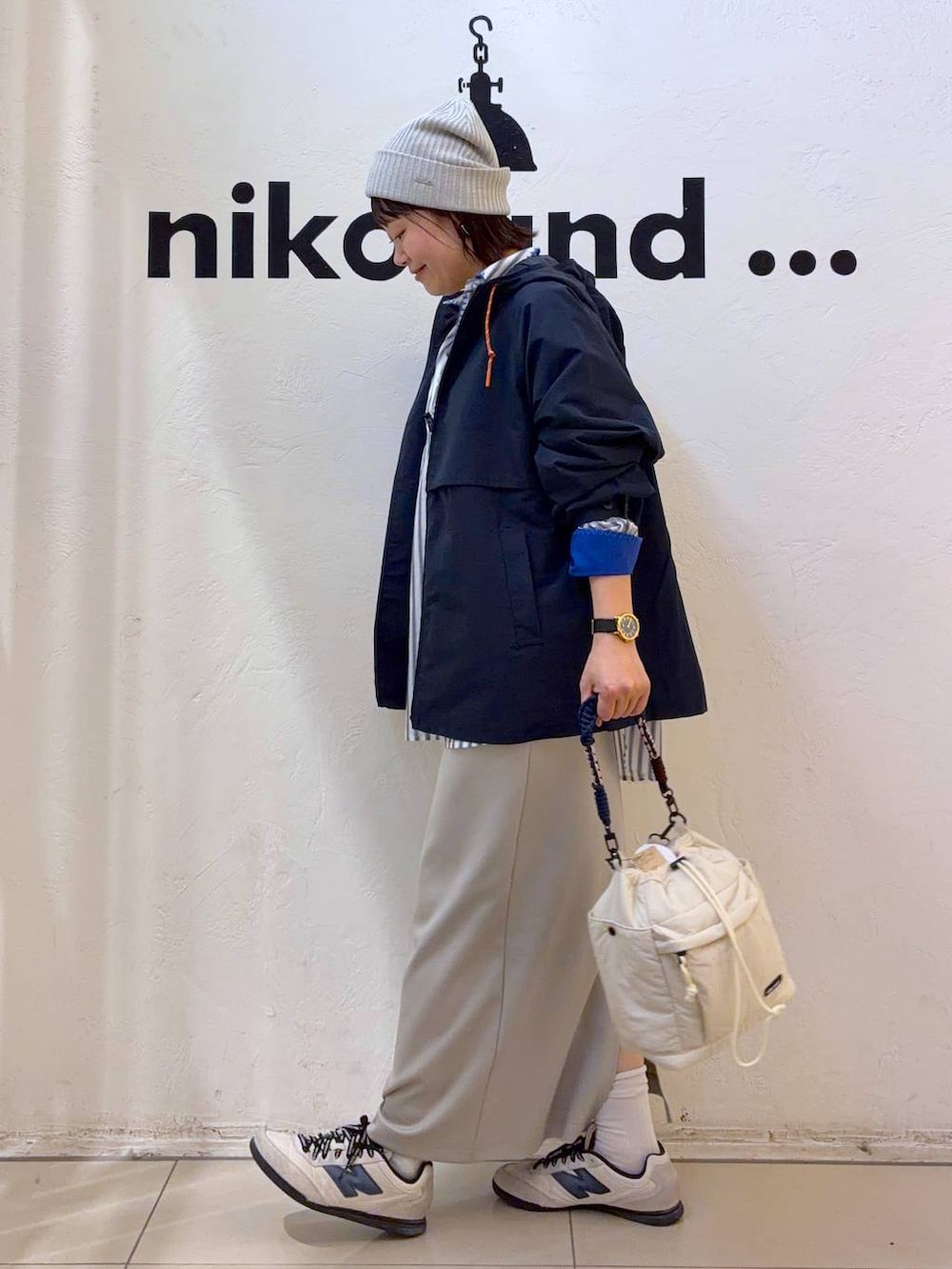 グレー系のタンクトップ、ベージュ系のスカート、ベージュ系のショルダーバッグを着用したレディースの春コーディネートの3枚目の写真