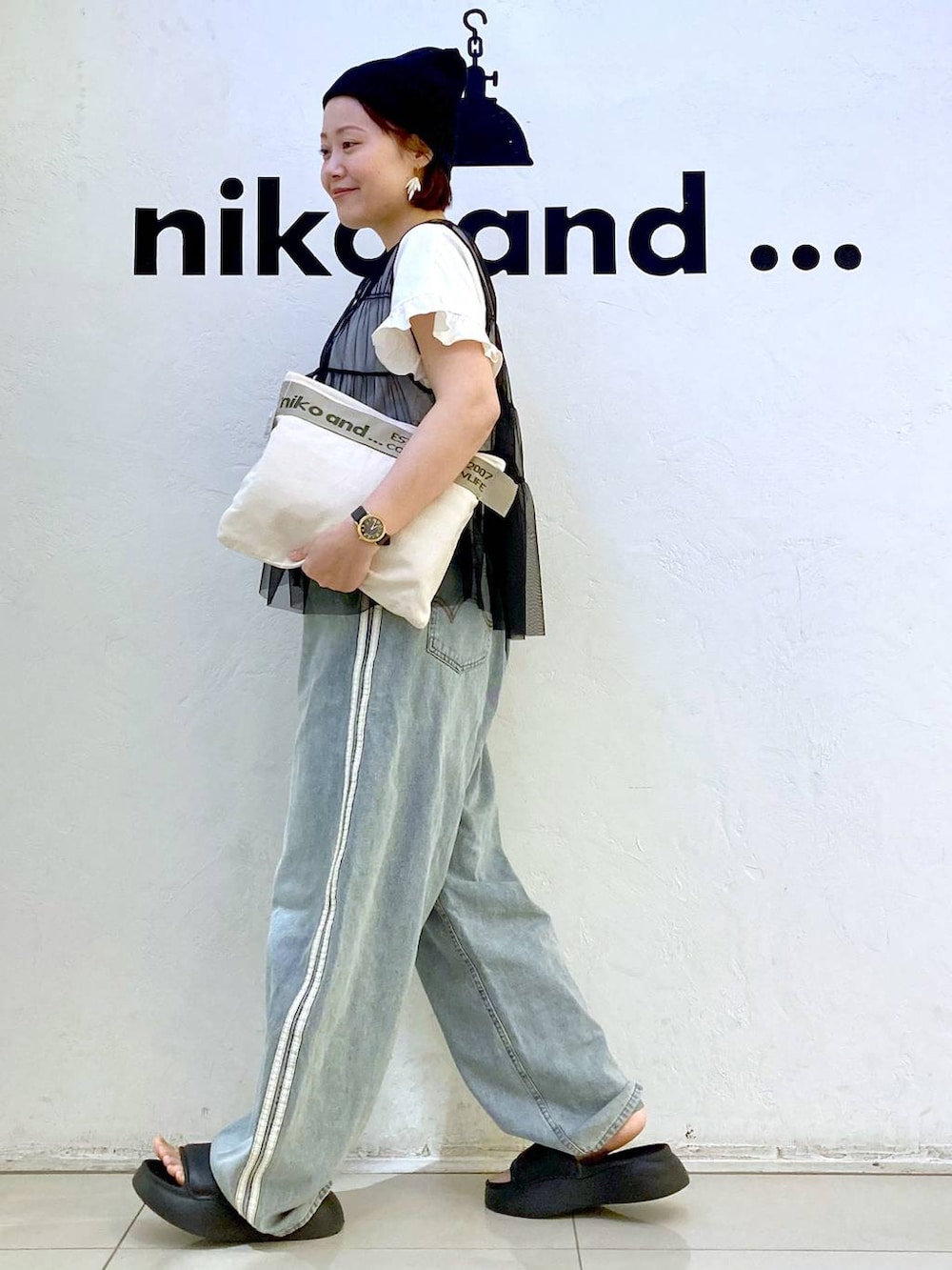 ブラック系のサンダル、ホワイト系のTシャツ/カットソー、ブラック系のベストを着用したレディースの夏コーディネートの5枚目の写真