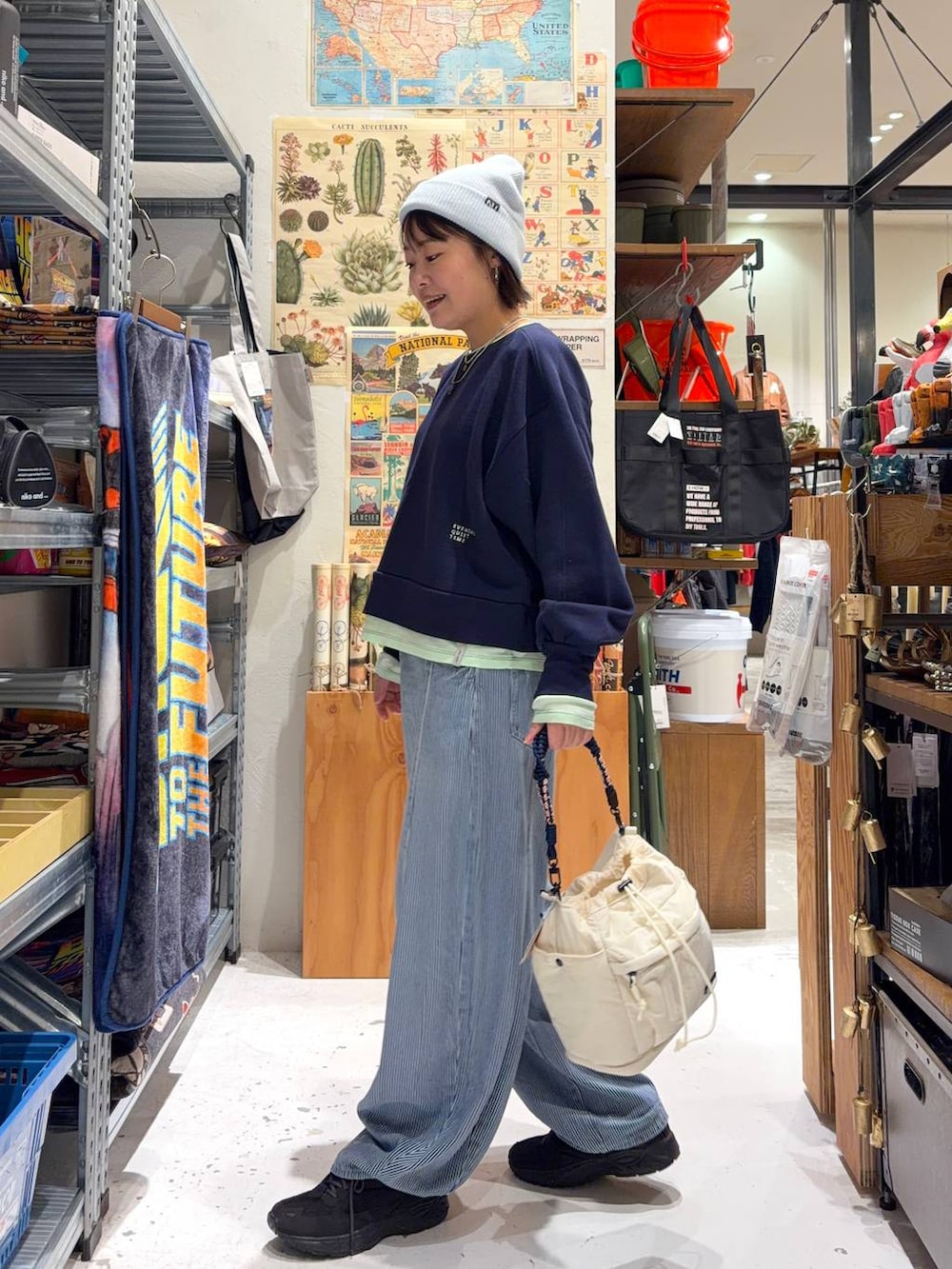 ブルー系のデニムパンツ、ブルー系のスウェット、ベージュ系のショルダーバッグを着用したレディースの冬コーディネートの4枚目の写真