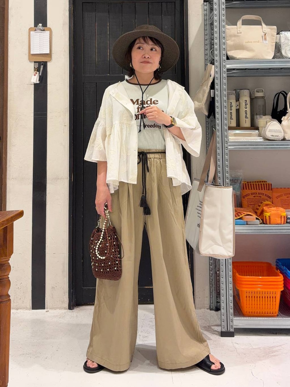 ベージュ系のその他パンツ、ホワイト系のシャツ/ブラウス、ブラウン系のショルダーバッグを着用したレディースの春コーディネートの3枚目の写真